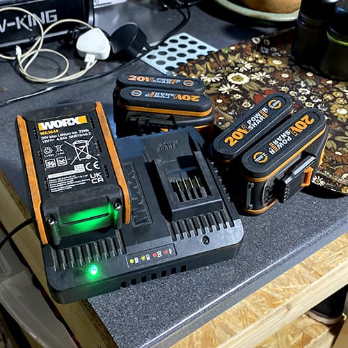 Worx 20V lithium batteries charging on dual port charger in workshop setup
